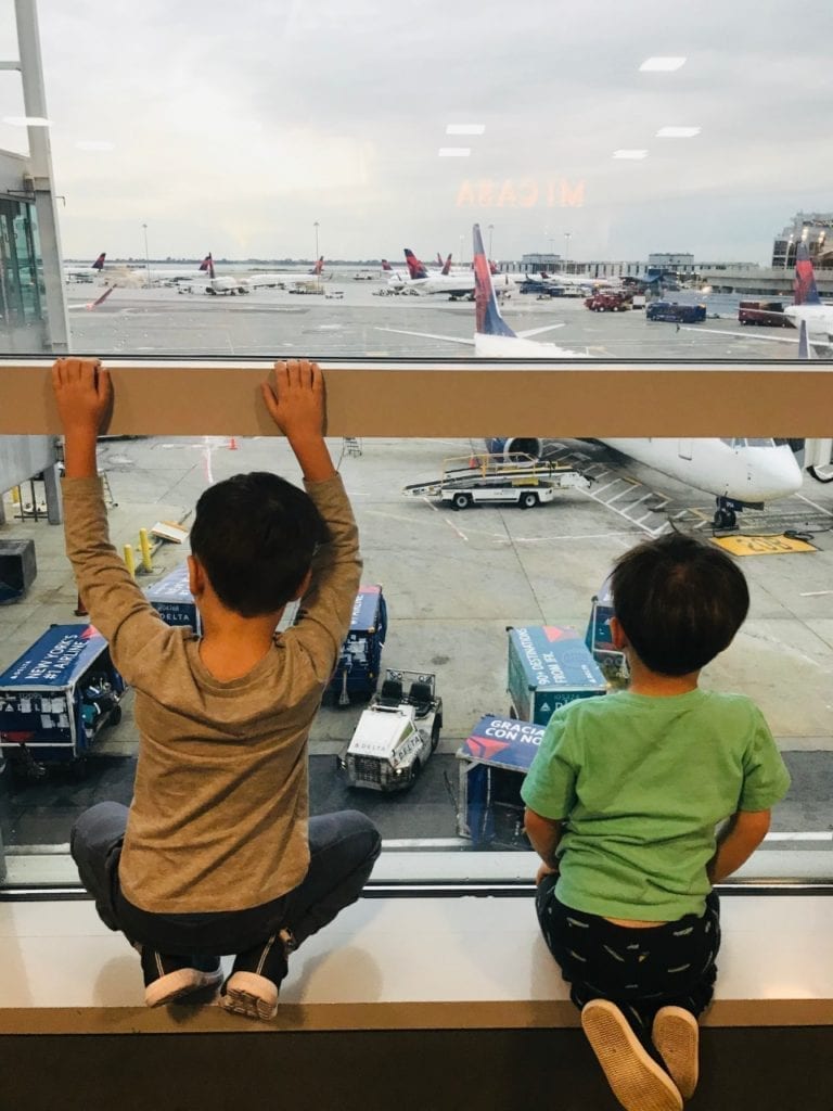 travel tips for traveling to europe with toddlers  - Two boys looking at the airplanes in the airport