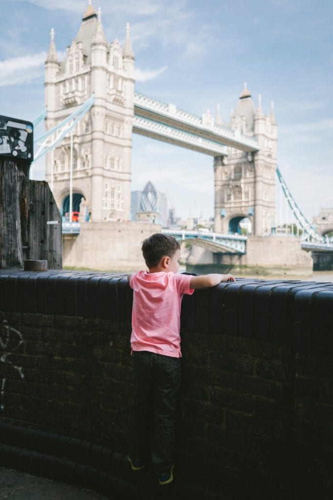 travel tips for traveling to europe with toddlers  - A boy looking at the Tower Bridge in London, England